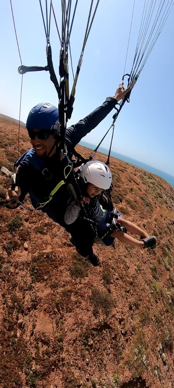 Pilote et passager en vol biplace au-dessus des falaises côtières