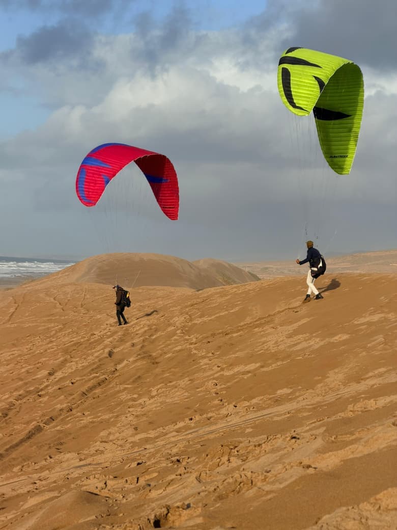 Deux parapentes jaune et rouge au-dessus de la dune côtière